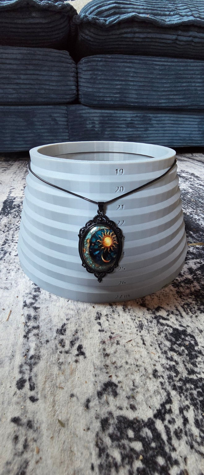 Celestial sun and moon necklace shown on size display