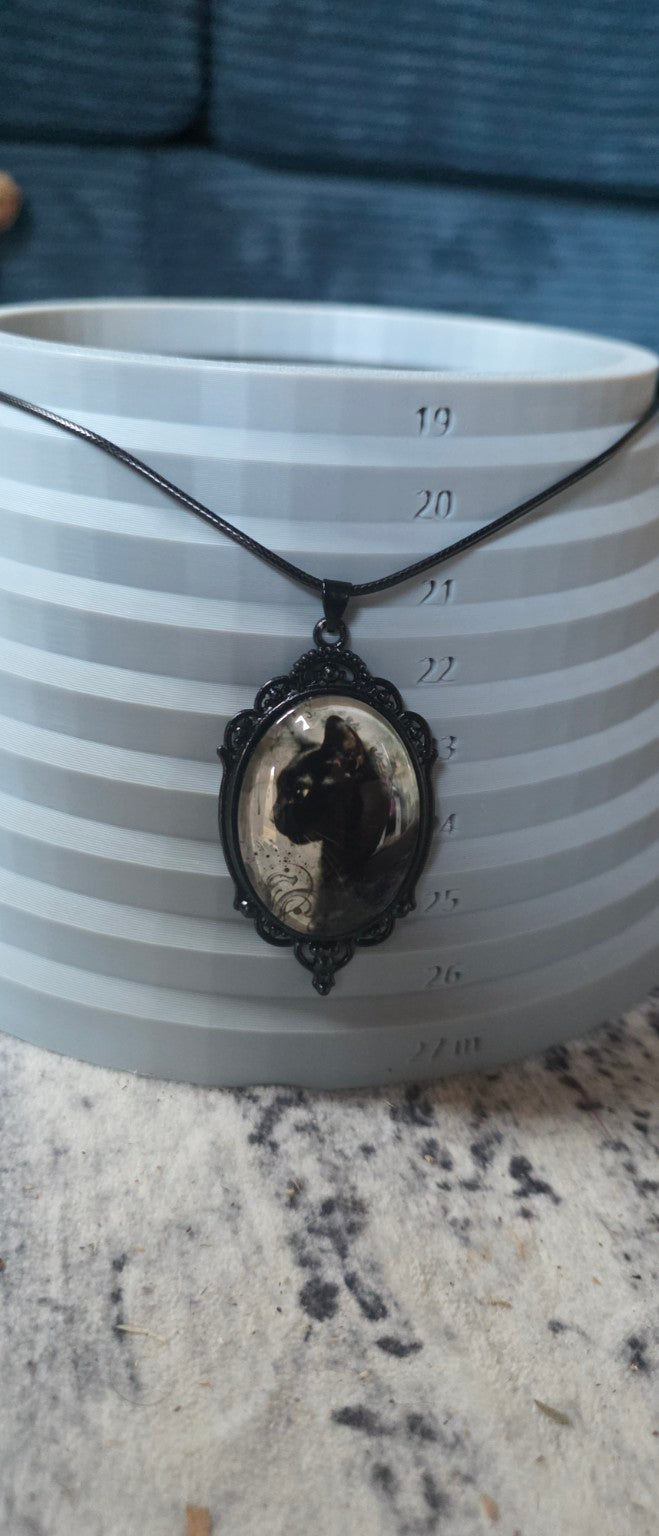 Black cat necklace shown on size display