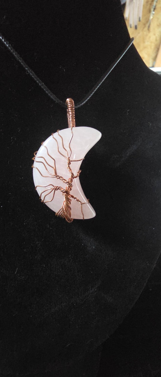 Close-up pale luminous crescent moon Tree of Life pendant
