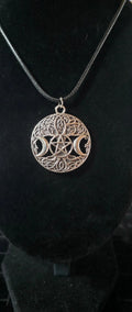 Close-up of silver-tone Triple Moon pentacle Celtic-style filigree pendant on black cord