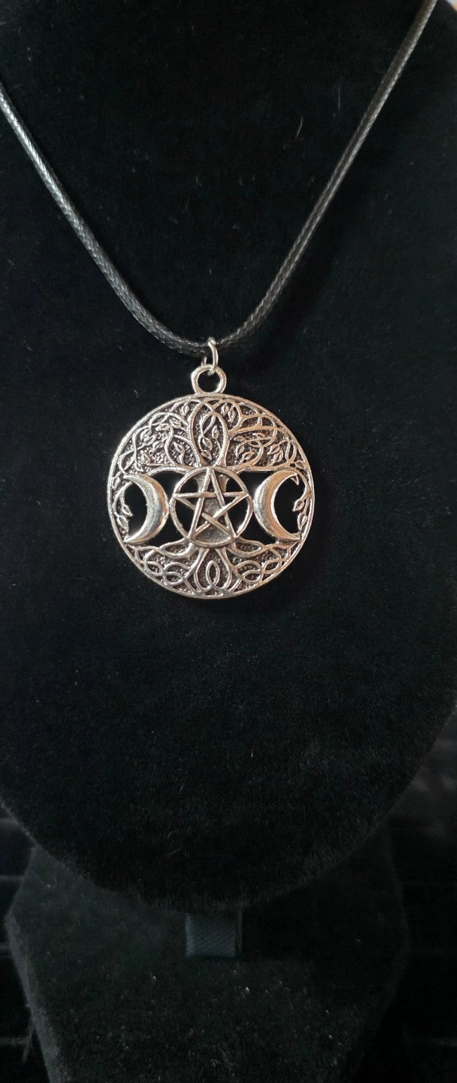 Close-up of silver-tone Triple Moon pentacle Celtic-style filigree pendant on black cord